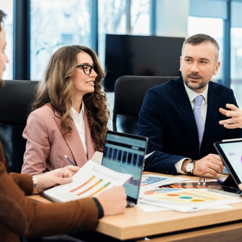 Business meeting in an office, workers discussing business affairs. Gadgets and papers on the table